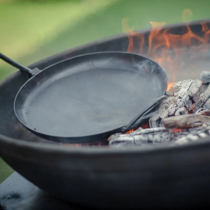 Firepits UK Long Handled Pan in use over a fire pit