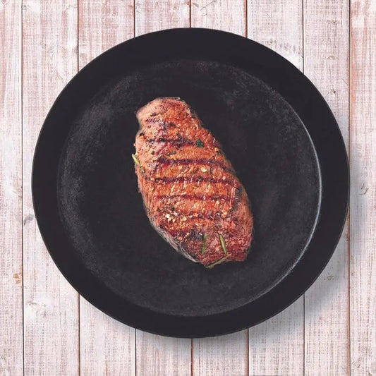 DeliVita Round Iron Dish with a cooked steak