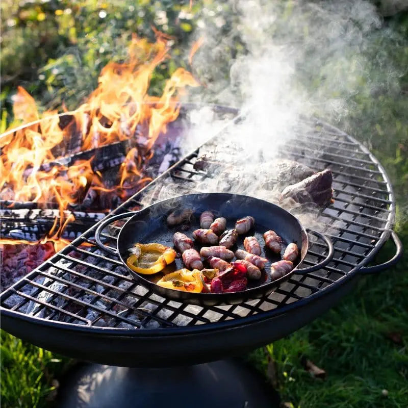 Firepits UK Half Moon Mesh BBQ Rack grilling over a fire pit